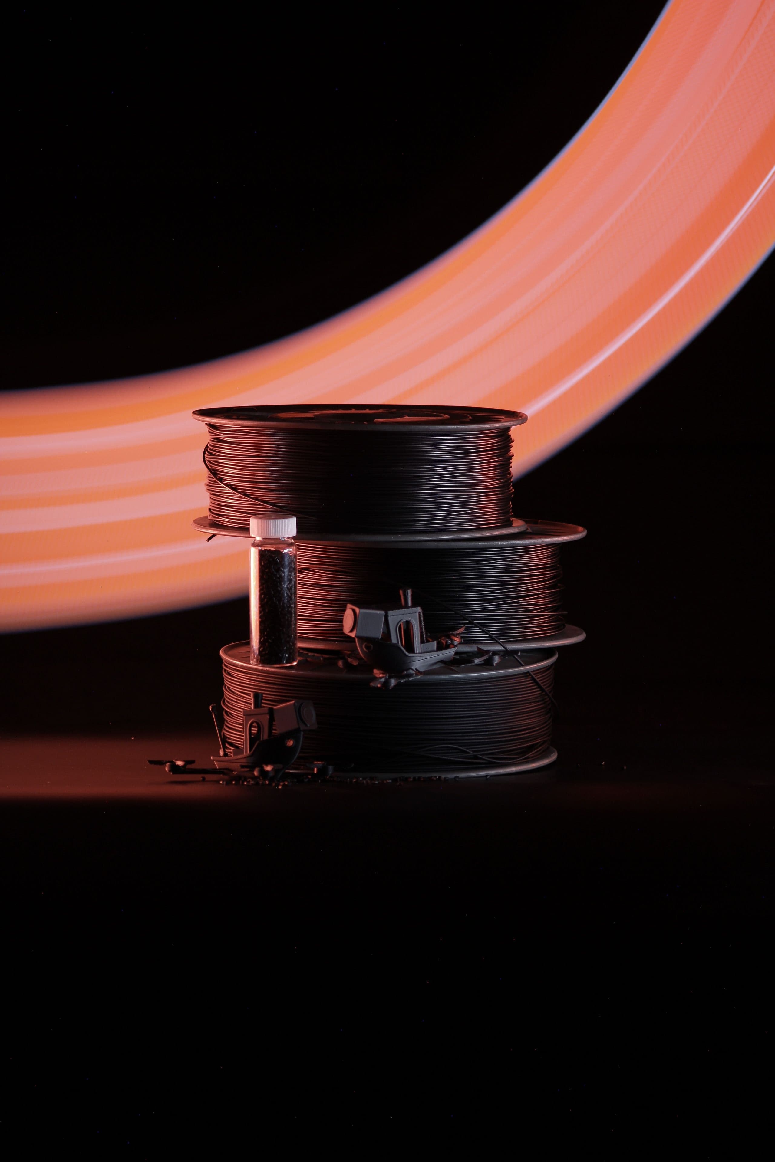AROS PPS high-temperature ESD 3D printing filament spools with printed industrial components and pellets. Photo by Johan Inghammar Magnusson.